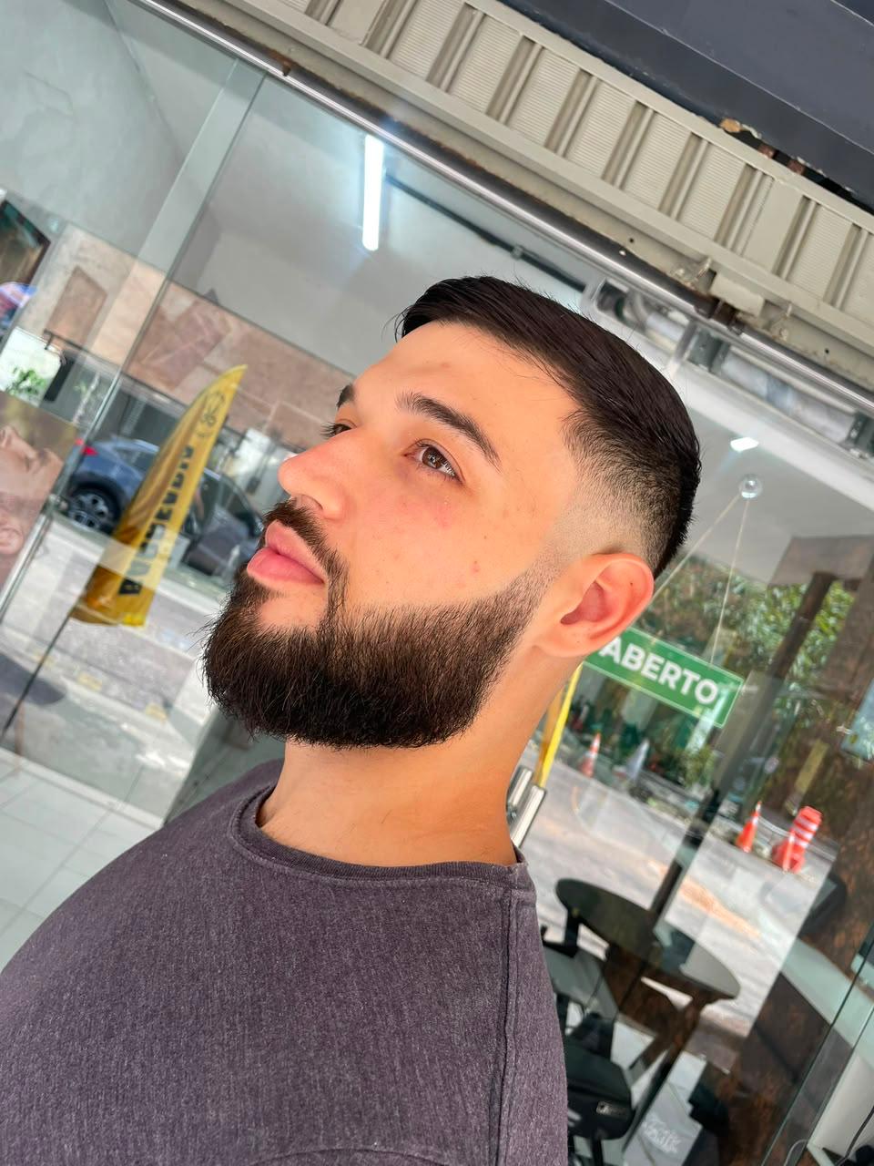 Cliente da barbearia do Clube do Corte com barba e degradê finalizados